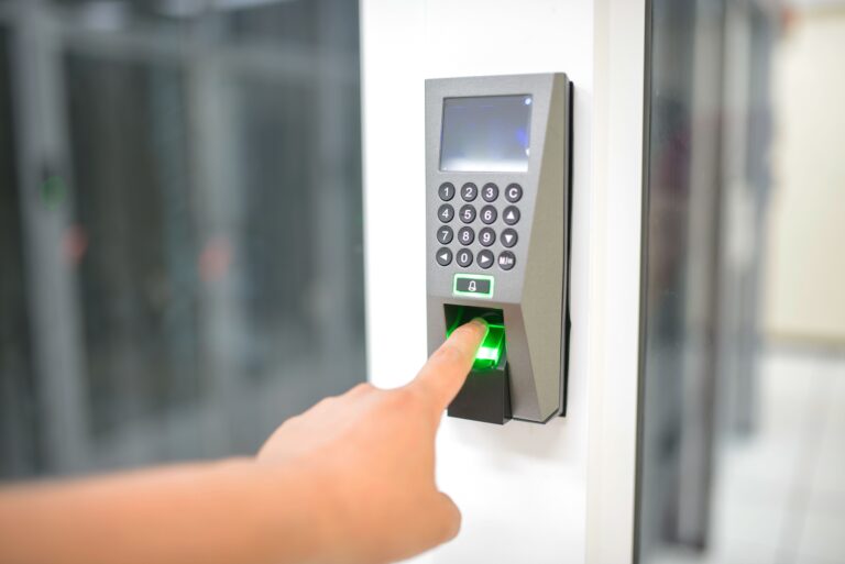 Person using a fingerprint scanner for secure entry, representing a biometric authentication system Singapore worksites use