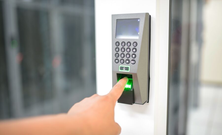 Person using a fingerprint scanner for secure entry, representing a biometric authentication system Singapore worksites use