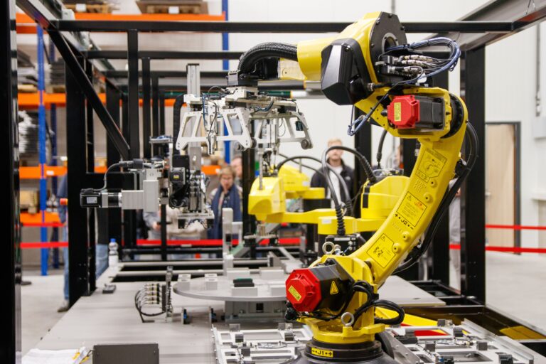 Yellow industrial robotic arm in a manufacturing facility, an example of a robotic arm Singapore production lines can adopt
