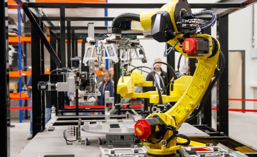 Yellow industrial robotic arm in a manufacturing facility, an example of a robotic arm Singapore production lines can adopt