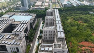 Aerial view of urban rooftops with solar panels, where a solar panel monitoring system Singapore owners rely on tracks output