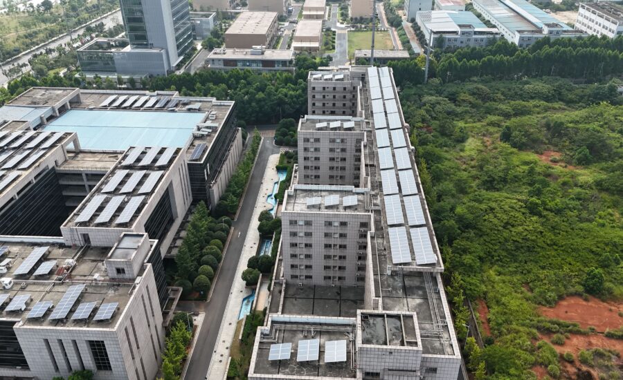 Aerial view of urban rooftops with solar panels, where a solar panel monitoring system Singapore owners rely on tracks output