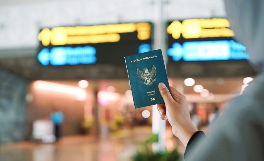 Penumpang memegang paspor Indonesia di terminal bandara tempat passport reader bandara dipakai