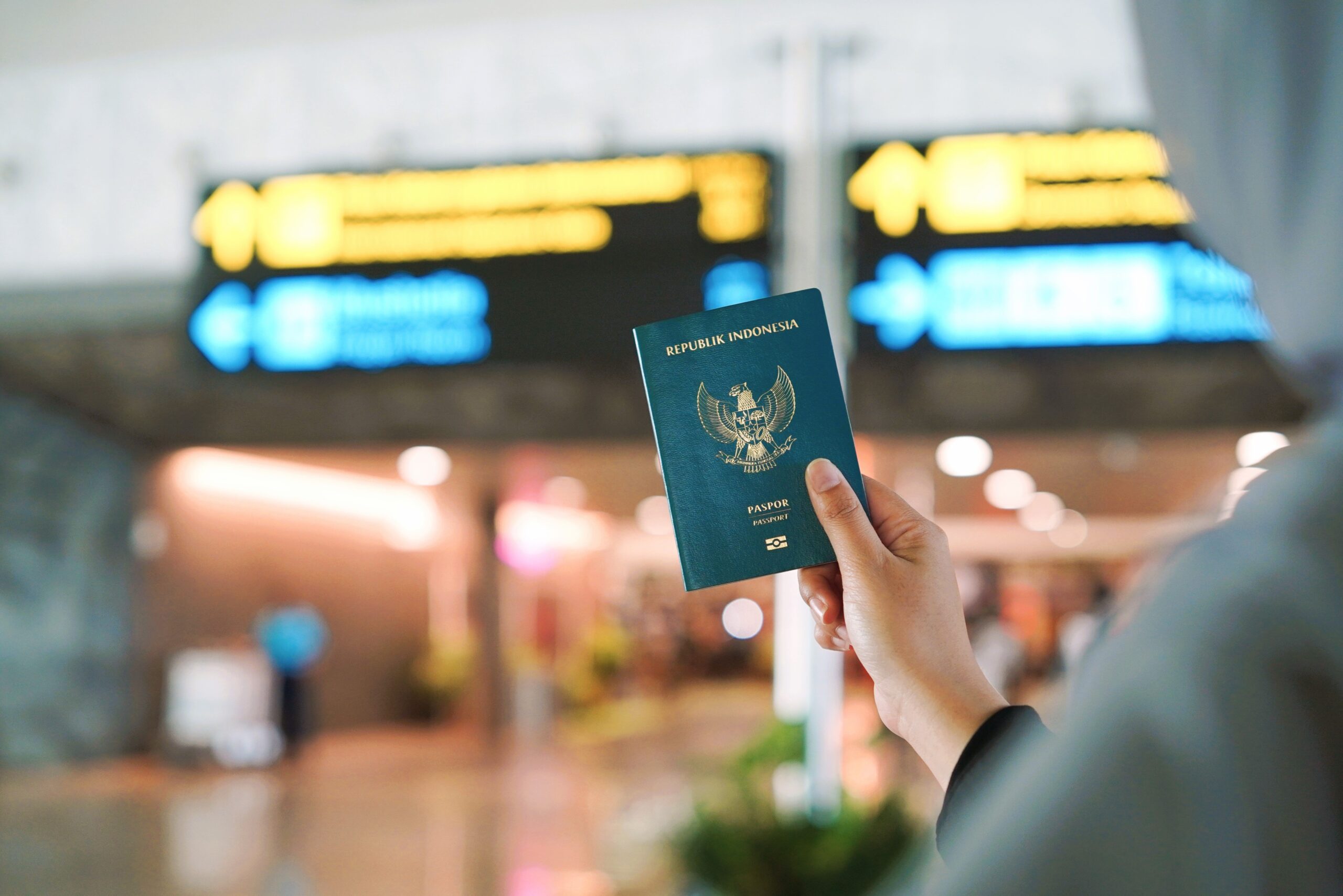 Penumpang memegang paspor Indonesia di terminal bandara tempat passport reader bandara dipakai