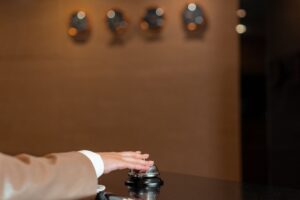 Tangan menekan bel di resepsionis hotel untuk registrasi tamu asing hotel