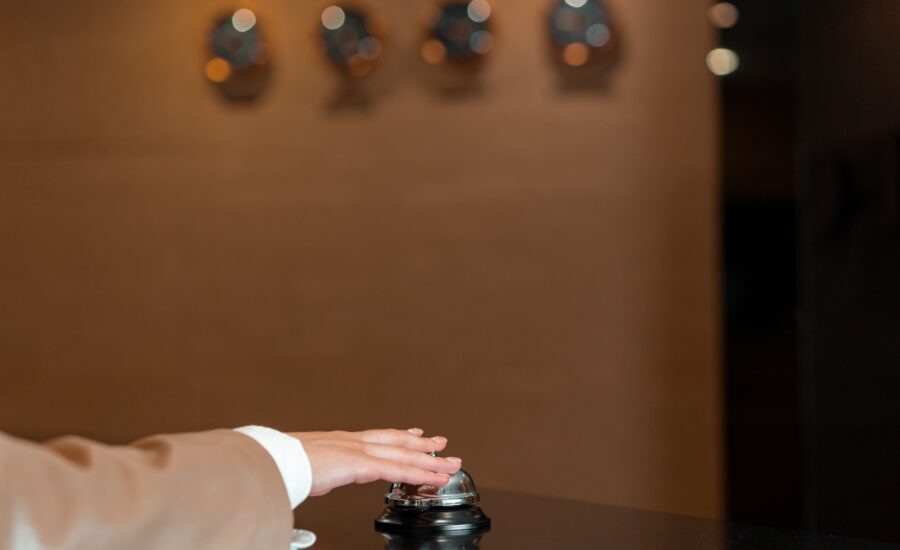 Tangan menekan bel di resepsionis hotel untuk registrasi tamu asing hotel